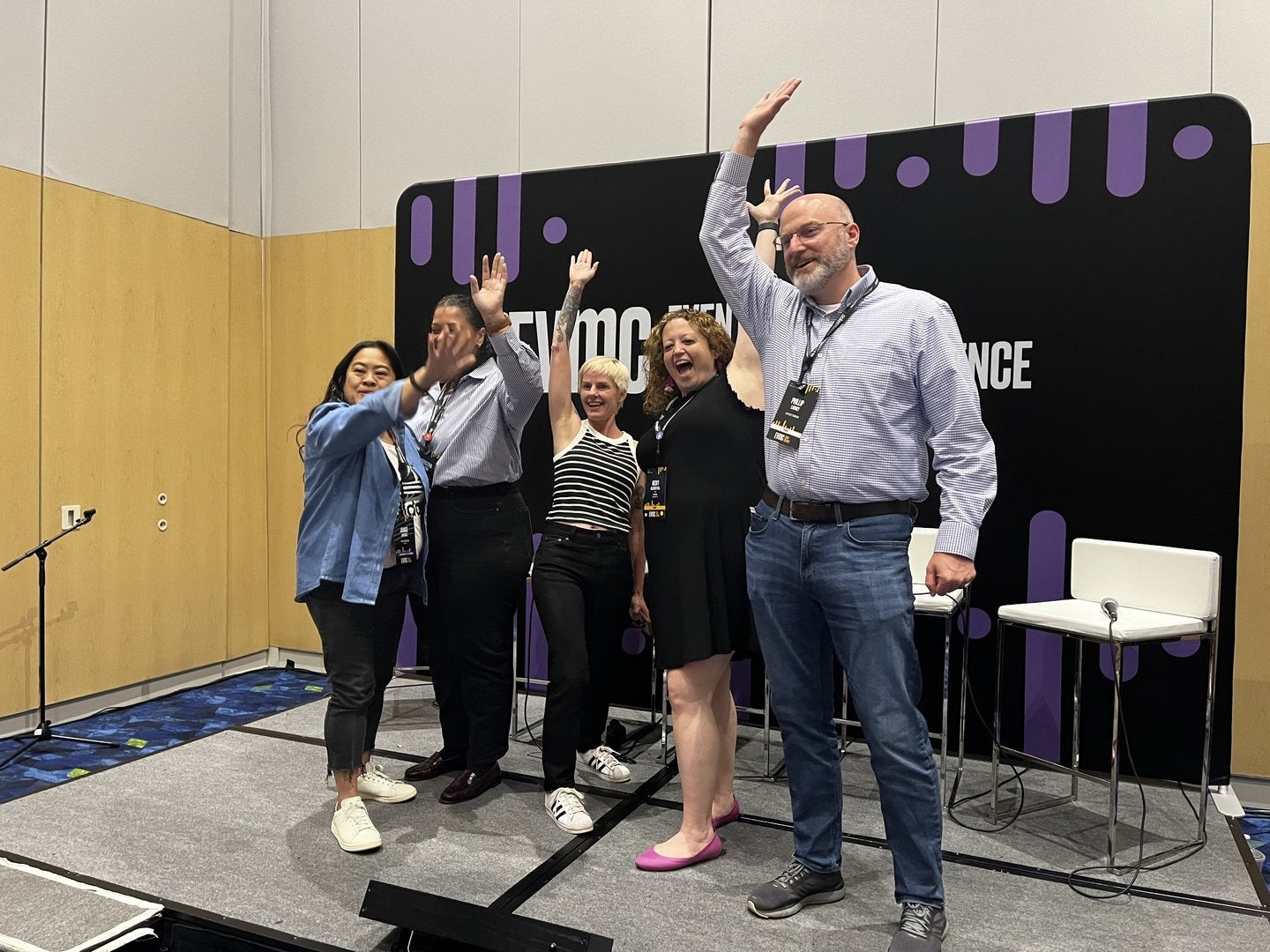 EVMC Panelists with their hands raised excitedly after their session.