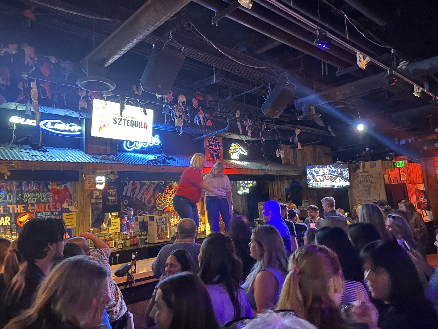 Crowd of EVMC attendees taking over the bar Coyote Ugly.